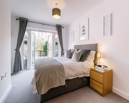 A neat bedroom with morning light coming through the window